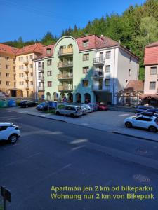um parque de estacionamento com carros estacionados em frente a um edifício em Apartment Mathis & MTB-garage em Jáchymov