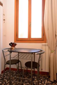 uma mesa e duas cadeiras num quarto com uma janela em Casa dea corte apartment em Veneza