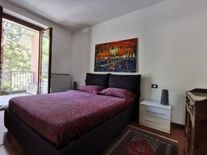a bedroom with a bed with a red comforter at Appartamento Gelsomino in Riva di Solto
