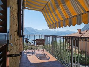 a balcony with a chair and a view of the mountains at Appartamento Gelsomino in Riva di Solto