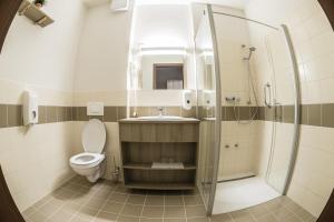 a bathroom with a toilet and a shower and a sink at Levendula Hotel in Algyő