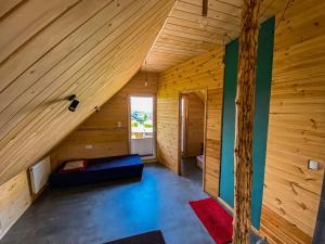 Zimmer im Dachgeschoss mit einem Bett in einer Holzhütte in der Unterkunft Agroturystyka u Moniki in Masłów