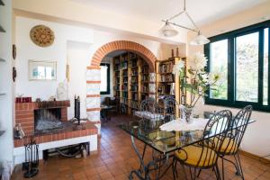een woonkamer met een glazen tafel en een open haard bij Villa Etna Pippo in Piedimonte Etneo