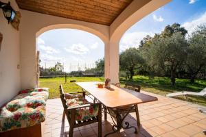un patio al aire libre con mesa y sofá en Villa Etna Pippo, en Piedimonte Etneo