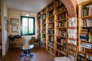een bibliotheek met houten planken gevuld met boeken bij Villa Etna Pippo in Piedimonte Etneo