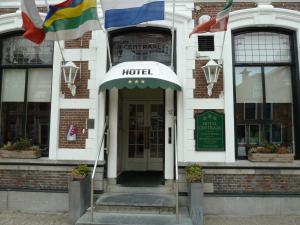 a hotel with flags in front of a building at Hotel Centraal in Harlingen