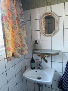 a bathroom with a sink and a mirror at Fantastisk havudsigt tæt på centrum in Tórshavn