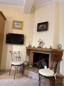 a living room with two chairs and a fireplace at Pyrgos in Pyrgi