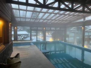 una piscina en un edificio con un gran ventanal en Las Aguas Río Bonito, en Villa La Angostura