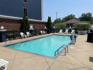 a large swimming pool with chairs and a building at Comfort Suites Olive Branch - Memphis South in Olive Branch