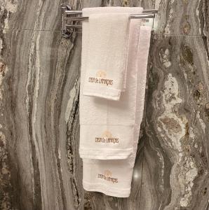 two white towels hanging on a wall in a bathroom at Casa de Lamaçais in Vilela