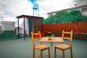 una mesa con 2 sillas y una mesa con una botella de vino en Casa El Guincho, Garachico en El Guincho