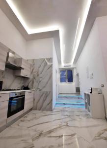 - une cuisine avec des placards blancs et un mur en pierre dans l'établissement Re Ferdinando Apartment, à Naples