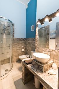 Al Palazzetto di Milo في ميلو: حمام مع مغسلتين ودش زجاجي