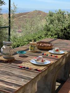 una mesa con platos de comida en una terraza de madera en Casale Etna Testa di Moro, 