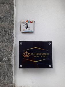 un panneau sur le côté d'un bâtiment dans l'établissement Re Ferdinando Apartment, à Naples