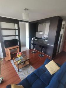 uma sala de estar com um sofá azul e uma cozinha em Departamento central Viña del Mar em Viña del Mar
