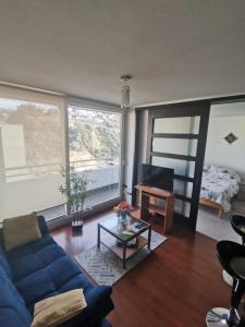 uma sala de estar com um sofá azul e uma mesa em Departamento central Viña del Mar em Viña del Mar