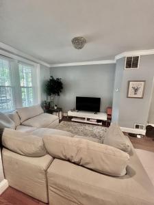sala de estar con 2 sofás y TV de pantalla plana en 3 Level 4 Bedroom Home w/ Parking in Adams Morgan en Washington