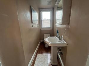 uma casa de banho com um lavatório e um espelho em 3 Level 4 Bedroom Home w/ Parking in Adams Morgan em Washington