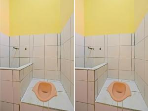La salle de bains est pourvue de toilettes roses et d'un mur jaune. dans l'établissement SPOT ON 92610 Barokah Kostel Syariah, à Semarang