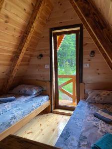 Dos camas en una cabaña de madera con ventana en Mountain house Drveni Raj, en Žabljak 51 fotos más