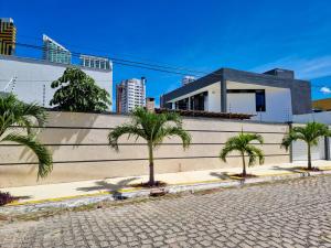 a row of palm trees in front of a building at Ponta Negra Temporada in Natal