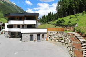 una casa su una collina con un muro di pietra di Chasa Patria a Ischgl