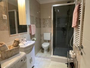 a bathroom with a sink and a shower and a toilet at Apartments Znjan in Split