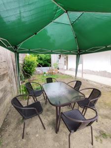 a table and chairs under a green umbrella at ATI MTA - Eco Hostel in Borjomi