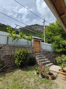 una pequeña casa con una puerta de madera y algunas plantas en ATI MTA - Eco Hostel, en Borjomi