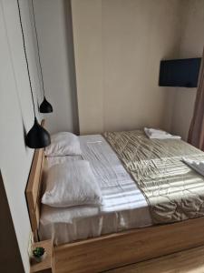 1 dormitorio con 1 cama con sábanas blancas y lámpara en Home Shekvetili en Shekhvetili