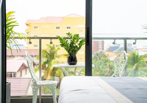 a room with a table and two chairs and a window at The Square Kampot Hotel in Kampot