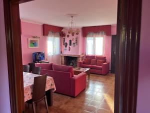 a living room with pink furniture and a fireplace at Chalet Major Beach Sanxenxo in Sanxenxo