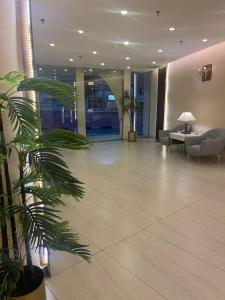 a lobby with a palm tree in a building at Fiori Hotels in Taif