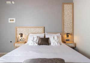 een slaapkamer met een groot bed met witte lakens en kussens bij Metropolitan Pearl Boutique Hotel in Chania