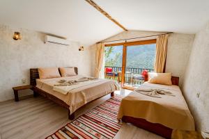 1 dormitorio con 2 camas y balcón en Manzara Bungalov, en Fethiye