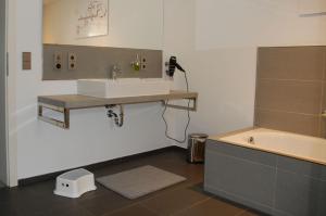 a bathroom with a sink and a bath tub at Ferienwohnung Hoffmann in Osburg +17 photos