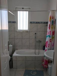 Skhoínos的住宿－Maisonette magnolia，带浴缸、卫生间和盥洗盆的浴室