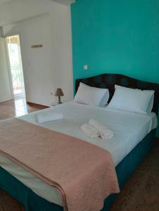 Skhoínos的住宿－Maisonette magnolia，一间卧室配有一张大床和两条毛巾