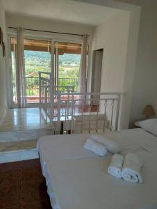 Skhoínos的住宿－Maisonette magnolia，一间带2张白色床的卧室和一个阳台