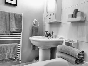 a bathroom with a sink and a toilet and towels at Rutland West Guest House in Filey