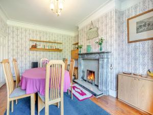 a dining room with a table and a fireplace at Belmont House in Hornby
