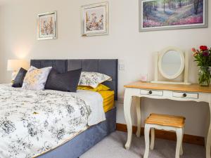 a bedroom with a bed and a table with a mirror at Bryn Bannon in Cilcain