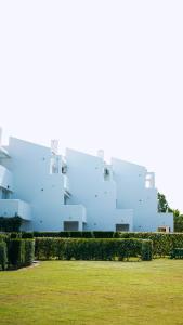 a white building with a green field in front of it at Novo Blue in Chiclana de la Frontera