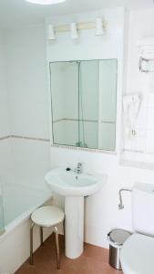 Baño blanco con lavabo y espejo en Novo Blue, en Chiclana de la Frontera