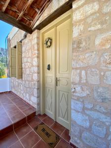 a front door of a stone house with a stone wall at To Petrino in Meyisti