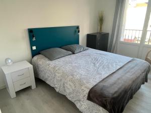 a bedroom with a large bed with a blue headboard at Vivez proche du port de plaisance - 2 chambres - Calme in Le Havre