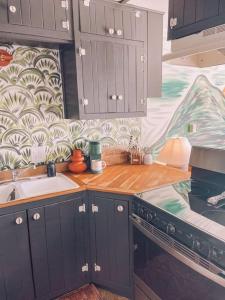 a kitchen with gray cabinets and a wooden counter top at Unique Condo on flight park! Watch hangliders fly! in Wildwood