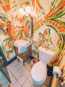 ein Bad mit einem WC und einer farbenfrohen Wand in der Unterkunft Unique Condo on flight park! Watch hangliders fly! in Wildwood